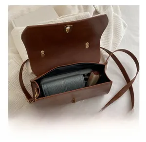 Detail view showing interior capacity of brown leather handbag with phone and wallet