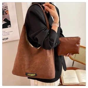 Detail of dark brown suede hobo bag set with matching zipper pouch and logo label