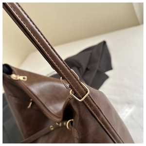 Vue détaillée du sac cabas en cuir marron avec boucle en métal doré ajustable