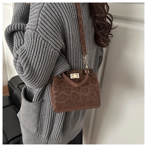 Detailed side view of the brown leopard print crossbody bag with golden twist lock