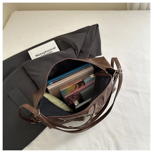 Détail d'un grand sac cabas marron foncé montrant sa capacité et son cuir mat élégant