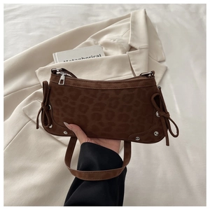 Detail of leopard print shoulder bag with side bow tie and silver stud accents