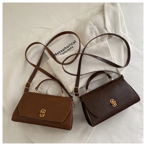 Detail view of vintage style faux leather handbags with elegant gold metal locks and straps