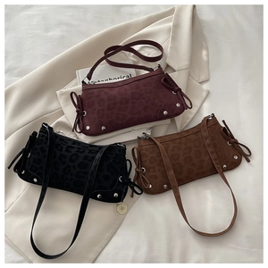 Detail of leopard print suede shoulder bags with ribbon bows and metallic studs