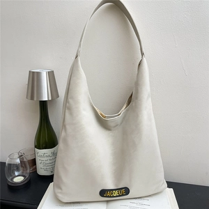 Minimalist beige large capacity tote bag with satin finish shown in modern studio setup