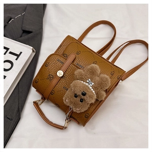 Detail view of brown vintage backpack with bear prints and a plush bear pendant accessory