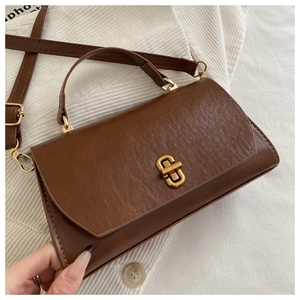 Detail of vintage caramel leather handbag with antique gold clasp and textured finish