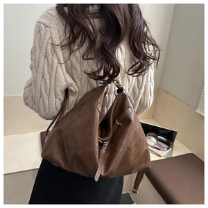 Détail du sac à bandoulière vintage marron foncé avec double fermeture éclair et boucle