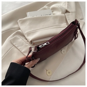 Close-up of a burgundy leopard print shoulder bag on a beige blazer background