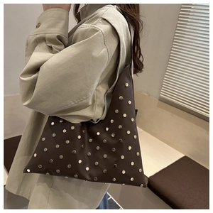 Detail of coffee brown shoulder bag featuring metallic silver studs and premium leather texture