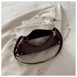 Interior view of burgundy shoulder bag showing storage for phone and cosmetics