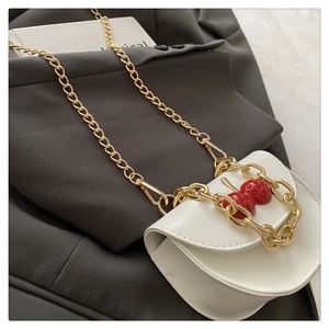Detail of white PU leather mini crossbody bag with red cherry pendant and gold chain