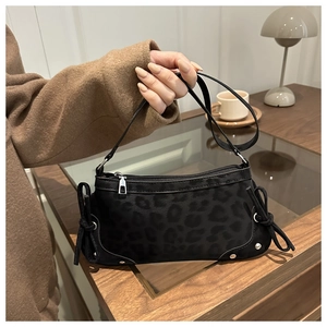 Close-up of leopard pattern shoulder bag with side eyelet bow details and silver hardware