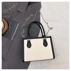 Detailed top view of beige checkered tote bag with black trim on grey suit jacket