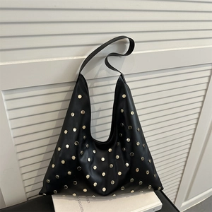 Retro black hobo shoulder bag with gold rivets against a minimalist white background