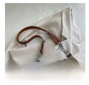 Detail of monogram M print tote bag with brown leather and silver chain strap