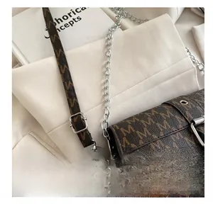 Detail of adjustable leather strap with silver buckle on vintage brown crossbody bag