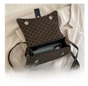 Detail of interior storage showing brown monogram crossbody bag holding a phone and wallet