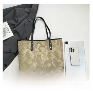 Quilted tote bag detail showing large capacity with light brown tie-dye pattern and leather handles