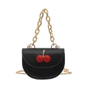 Black mini saddle bag with cherry charm and gold chain straps on white background