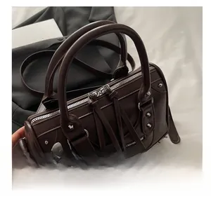 Close-up of retro chocolate brown leather Boston bag with silver studs and long fringe