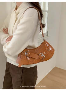Close-up of caramel brown retro shoulder bag with double straps and bear charm detail