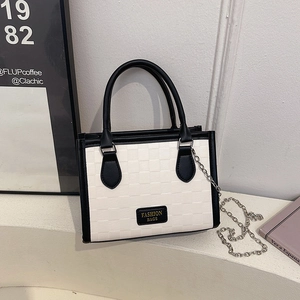 Checkerboard pattern tote bag with dual handles and metal chain strap in modern setting