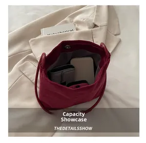 Capacity display of burgundy corduroy bucket bag showing phone and wallet storage