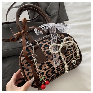Dettaglio borsa Boston leopardata con fiocco di perle, pizzo e ciondoli a ciliegia