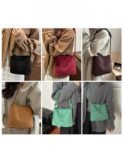 Detail view of suede bucket bag colors with knotted rope handles and embossed text