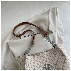 Détail du sac cabas vintage avec monogramme, chaînes métalliques et logo M argenté