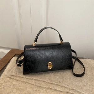 Classic vintage black handbag with glossy textured finish and gold metal buckle