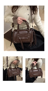 Detail of vintage brown Boston bag with silver studs, zipper pocket, and long tassels