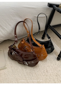 Close-up of three vintage-style PU leather underarm bags in brown, caramel, and black