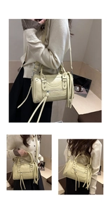 Close-up of cream yellow punk handbag showing silver rivets and fringe zipper details