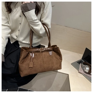 Detail of vintage brown suede tote bag with leather strap and decorative buckle