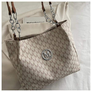 Vue détaillée du sac cabas à monogramme avec bandoulière chaîne et logo en métal