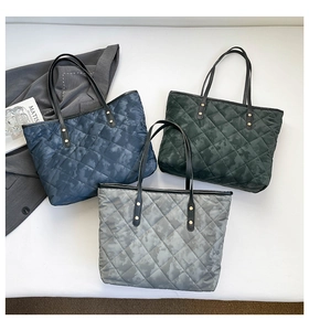 Detailed view of quilted tote bags in navy blue, green, and grey with camo texture
