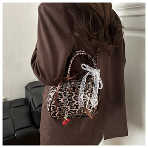 Dettaglio borsa bowling leopardata con ciondolo a ciliegia e fiocco di pizzo