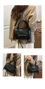 Detailed view of black rivets and tassels on minimalist motorcycle Boston handbag