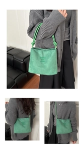 Close-up of green suede bucket bag with fashion and classic embroidery detail