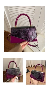 Detail of purple crocodile pattern leather handbag with gold metal hardware and top handle