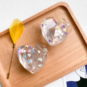 Detailed close-up of heart-shaped crystal phone stands with colorful sequins and pearls