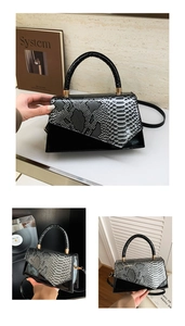 Detail of a trapezoid handbag featuring mixed textures and golden hardware accents