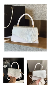 Detail of white PU leather handbag featuring asymmetric flap and faux snake skin texture