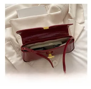 Macro view of burgundy patent leather bag interior showcasing its capacity for a smartphone