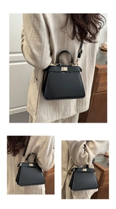Detailed view of black matte leather trapezoid handbag with golden twist lock closure