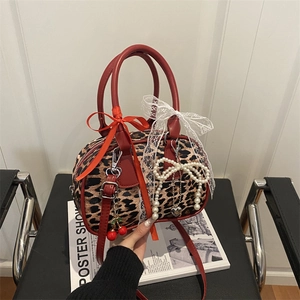 Borsa Boston leopardata con manici in pelle rossa e fiocchi decorativi in pizzo