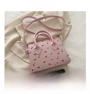 Dettaglio della borsa rosa con stampa a ciliegia con doppi manici e riferimento taglia