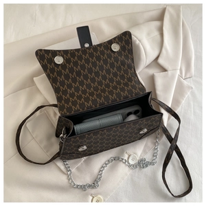 Close-up of brown monogram crossbody bag showing interior capacity and magnetic buckles